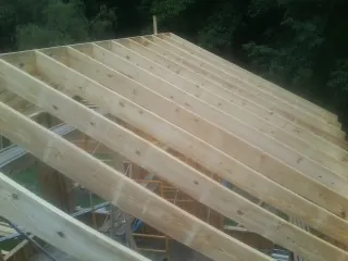 New roof rafters set over an addition before sheathing in Essington