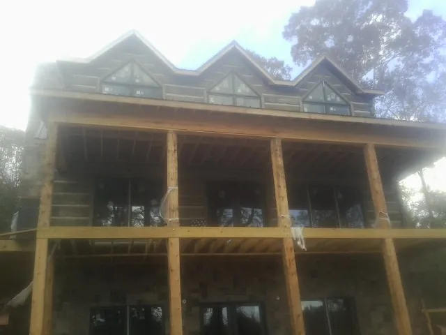Dormers and porch framing on a large log home under construction — Roof Coating work by our crew in Essington